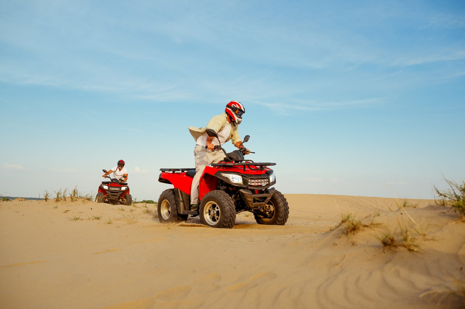 Man in helmet rides on atv in desert sands. Male person on quad bike, sandy race, dune safari in hot sunny day, 4x4 extreme adventure, quad-biking