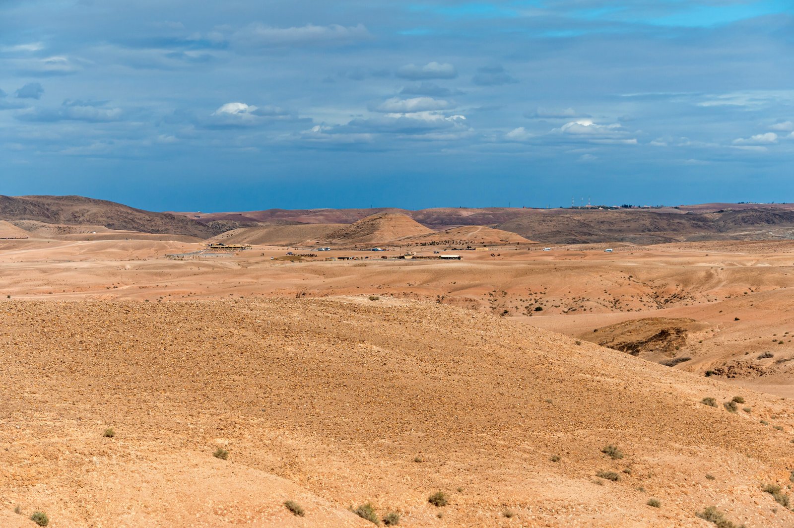 Expansive landscape showcasing the dry Agafay desert in Morocco against snowy peaks.